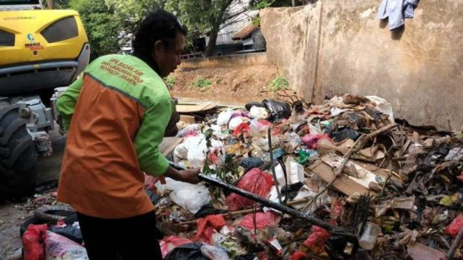 Petugas menunjukkan limbah jeroan kurban yang dibuang di Kali Baru, Kramat Jati.