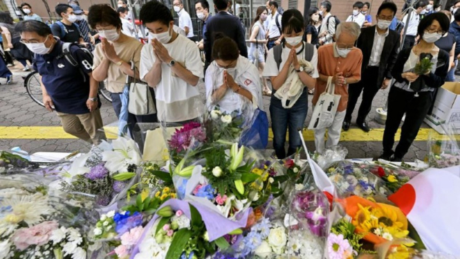 Warga Jepang memberikan bunga dan berdoa untuk Shinzo Abe di lokasi penembakan.