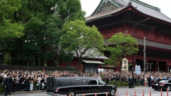 Mobil yang mengangkut jenazah Shinzo Abe di Tokyo melewati kerumunan 