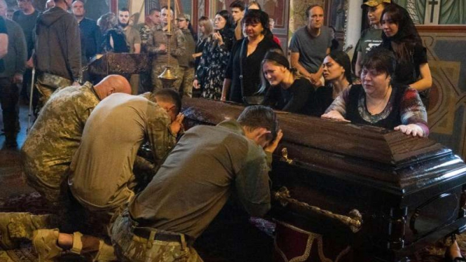 Prajurit Ukraina di Kiev berdoa di peti mati rekan yang tewas di serangan Rusia