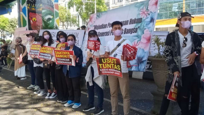 Sejumlah orang berunjuk rasa di depan gedung Pengadilan Negeri Malang, Jawa Timur, Rabu, 20 Juli 2022, untuk menuntut agar Julianto Eka Putra, terdakwa kekerasan seksual terhadap beberapa siswi sekolah SPI dihukum seberat-beratnya.