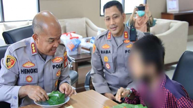 Bocah yang dipasung tengah makan bersama Kapolres Metro Bekasi Kombes Hengki.