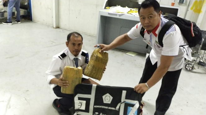 Los agentes vacían las maletas de la comunidad, que contenían bidones de Zamzam.