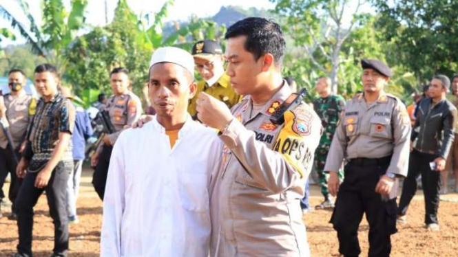 Kepala Polres Jember AKBP Hery Purnomo berbincang dengan salah satu warga yang rumahnya dibakar sekelompok orang di Dusun Baban Timur, Desa Mulyorejo, Kabupaten Jember, Kamis, 4 Agustus 2022.