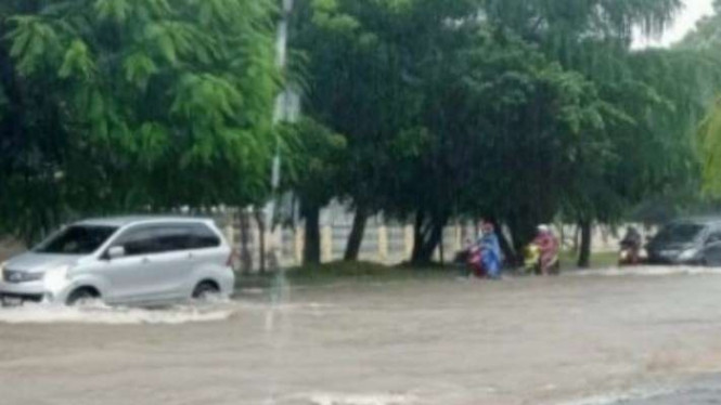 Mobil melintas di wilayah tergenang air akibat hujan deras di Kota Kupang, NTT.