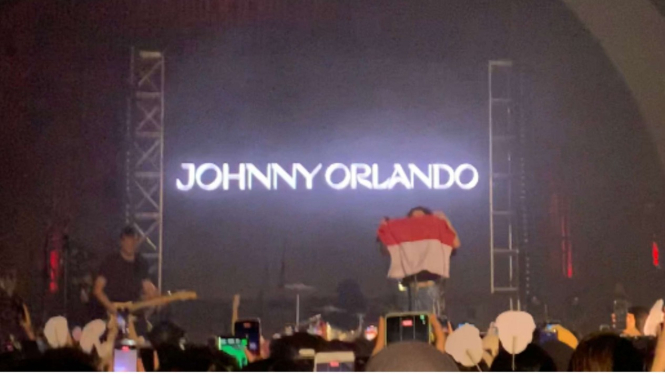 Johnny Orlando bentangkan bendera merah putih di atas panggung konser NHC