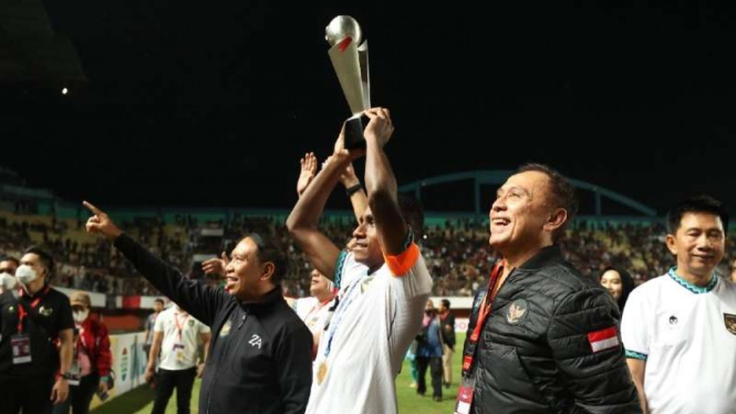 Kapten Timnas Indonesia U-16 Iqbal Gwijangge dengan trofi Piala AFF U-16