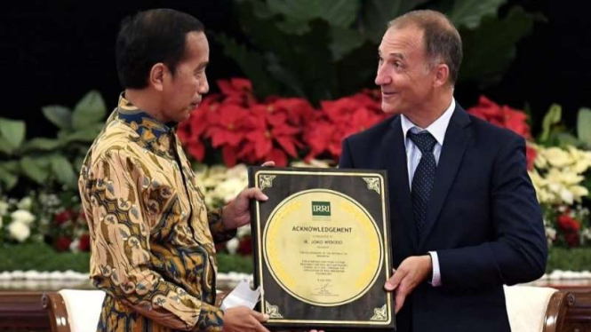 Presiden Jokowi saat menerima Plakat Penghargaan IRRI