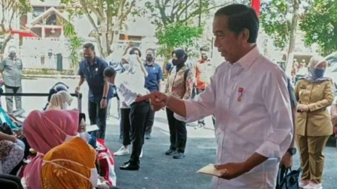 Presiden Joko Widodo tengah memberikan bantuan sembari berdialog dengan warga Bandarlampung, Lampung, Sabtu, 3 September 2022.