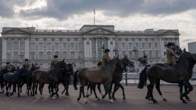 Satun polisi berkuda melewati depan Istana Buckingham, London