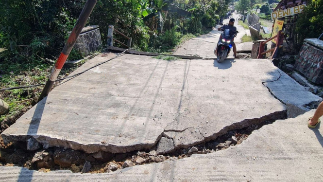 Sejumlah jalan beton di Kampung Curug, Desa Bojong Koneng, Kecamatan Babakan Madang, Kabupaten Bogor, Jawa Barat, retak dan rusak akibat tanah bergerak, Kamis, 15 September 2022.