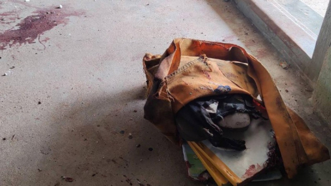 Sebuah tas sekolah tergeletak di samping noda darah kering di lantai usai serangan militer Myanmar.