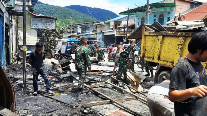 Aparat gabungan membersihkan puing-puing bangunan ruko bekas kebakaran di Pasar Sarulla, Kecamatan Pahae Jae, Kabupaten Tapanuli Utara, Sumatera Utara, Sabtu, 1 Oktober 2022, setelah daerah itu diguncang gempa pada dini hari.