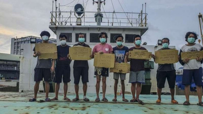 Delapan ABK asal Indonesia yang terkatung-katung memegang poster minta dibantu