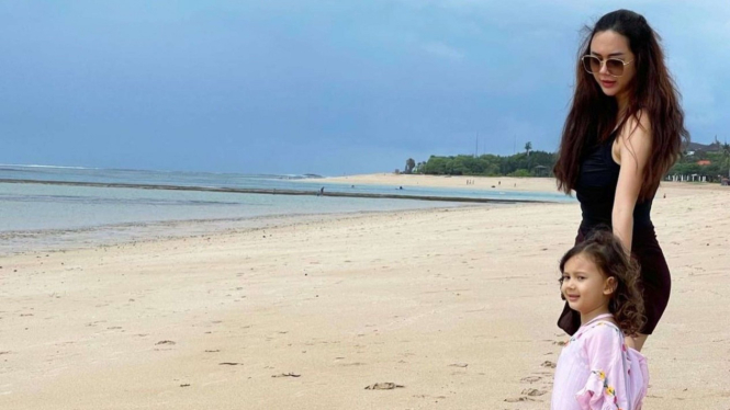 Aura Kasih dan anaknya, Bella bermain di pantai 