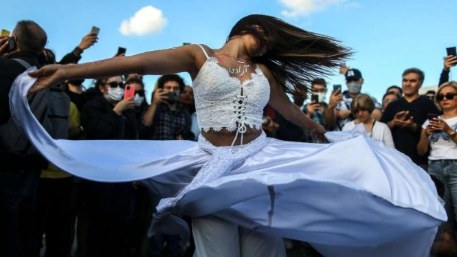 Seorang perempuan di Turki  menari di protes antihijab atas kematian Mahsa Amini