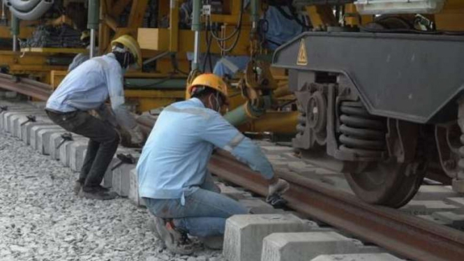 Pekerja memasang rel kereta cepat Jakarta-Bandung.