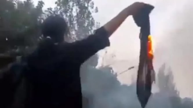 Gambar Nika Shakarami membakar hijab sebagai bentuk protes terhadap pemerintah Iran.
