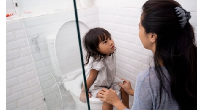 Fotos de padres enseñando a sus hijos a ir al baño.