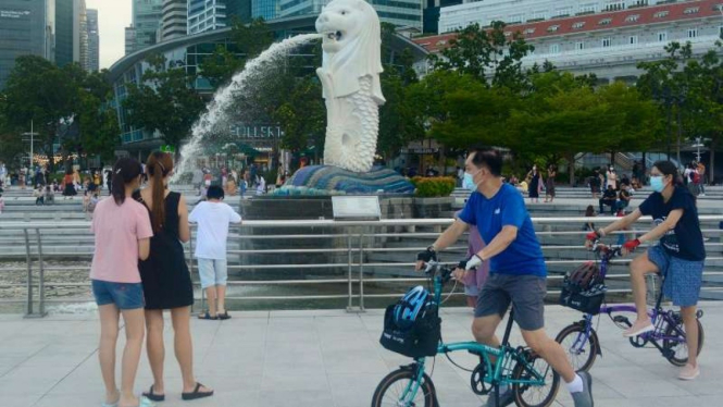 Warga Singapura beraktivitas dengan menggunakan masker.