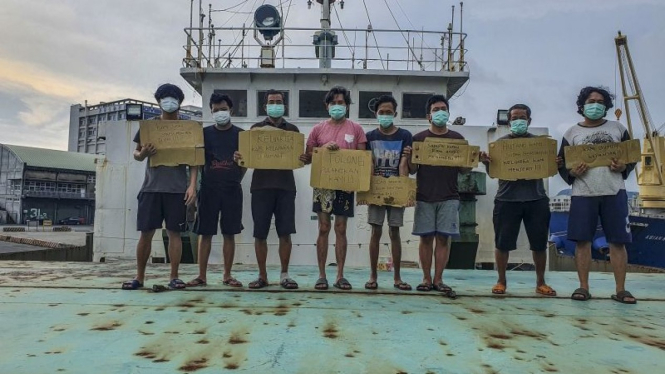 ABK asal Indonesia yang terkatung-katung memegang poster berisi permintaan untuk pulang di atas kapal kargo yang diduga milik perusahaan asal Hong Kong di Pelabuhan Kaohsiung, Taiwan, Kamis (11/8/2022).