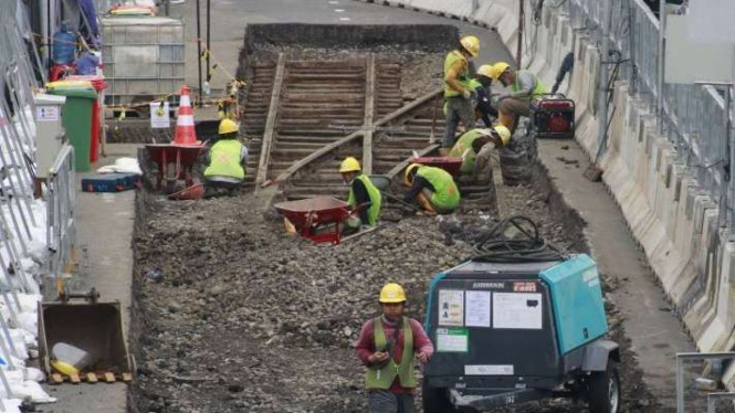 Sejumlah pekerja membongkar aspal yang menutupi rel trem di proyek MRT Fase 2A.