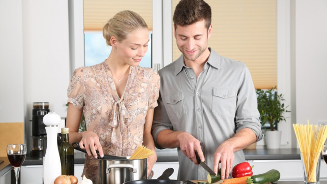 Suami istri memasak bersama