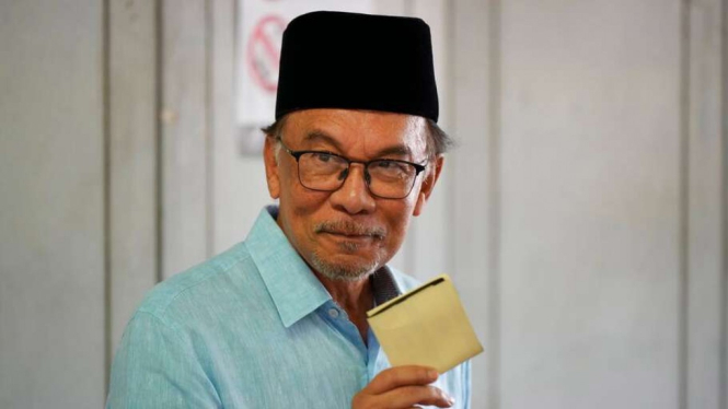Pemimpin oposisi Malaysia Anwar Ibrahim menunjukkan surat suaranya.