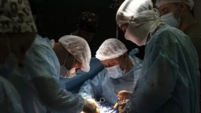 Dokter Ukraina melakukan operasi bedah meski dalam keadaan mati lampu. 