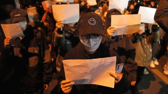 Para demonstran di Beijing China membawa kertas putih memprotes pembatasan COVID-19.