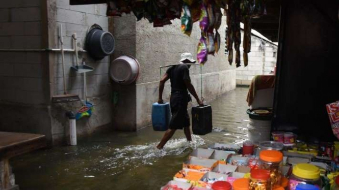 Arsip Foto - Warga mengangkut air saat banjir rob melanda pemukiman Muara Angke.