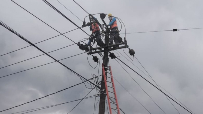 Petugas PLN saat bertugas mengerjakan jaringan listrik.