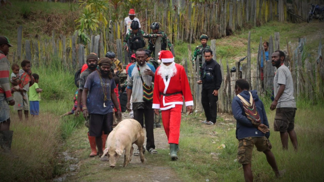 VIVA Militer: Pasukan Yonif Para Raider 305/Tengkorak  bagikan babi Natal.