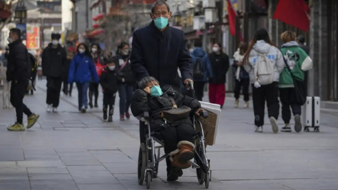 Orang-orang memakai masker di Beijing, China.