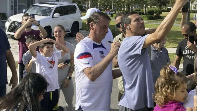 Mantan Presiden Brasil, Jair Bolsonaro, (tengah) bertemu dengan para pendukungnya di tempatnya berlibur di Orlando, Florida, AS.