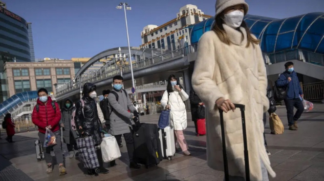 Warga Beijing memakai masker untuk melindungi diri dari COVID-19.