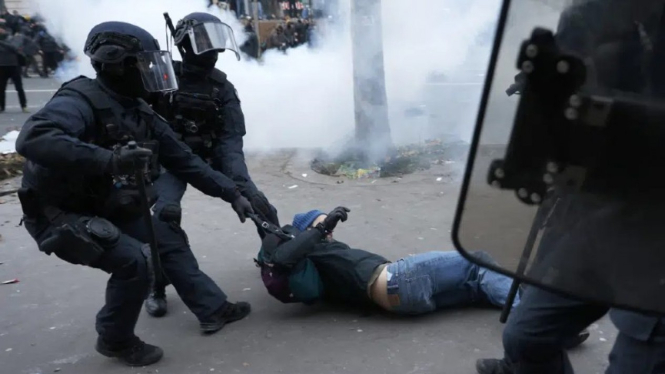Polisi menarik demonstran yang melakukan protes di jalan-jalan menentang rencana perubahan masa pensiun di Paris, Prancis.