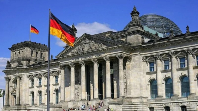 Ilustrasi - Bendera Jerman terlihat di depan gedung Reichstag di Berlin, Jerman.