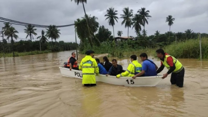 Polisi menggunakan perahu untuk mengevakuasi warga dari banjir di Kota Marudu, Sabah, 26 Januari 2023.