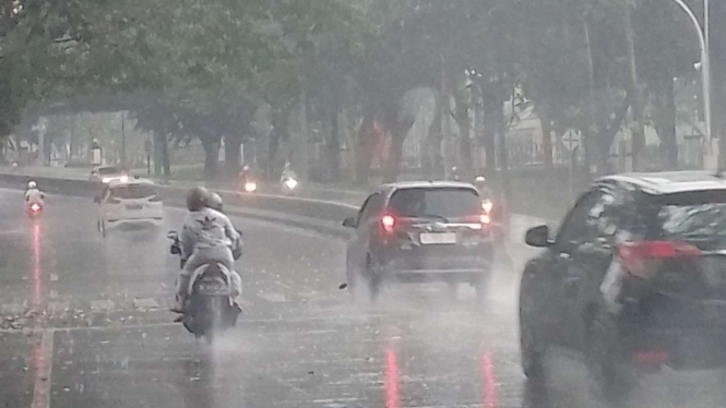 Hujan mengguyur di Jalan Nasional.