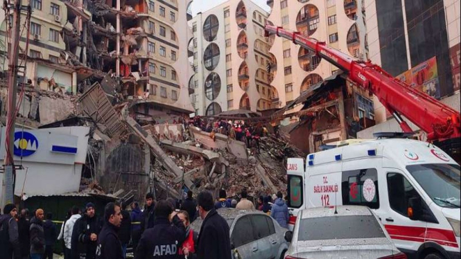 Petugas berusaha menjangkau warga yang terjebak di bangunan akibat gempa Turki.