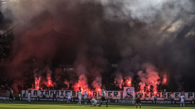 Para pendukung Nice menyalakan flare saat hadapi Lille