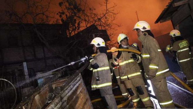Sejumlah petugas berusaha memadamkan api yang membakar rumah warga imbas kebakaran Depo Pertamina Plumpang, kawasan Jalan Koramil, Rawa Badak Selatan, Koja, Jakarta Utara, Jumat malam, 3 Maret 2023.