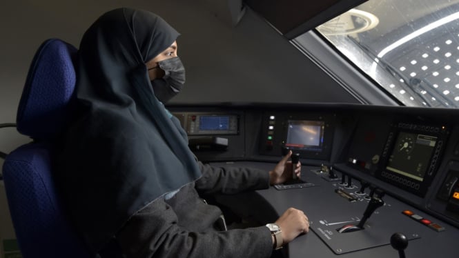 Seorang wanita Arab Saudi bekerja sebagai kondektur kereta api. 