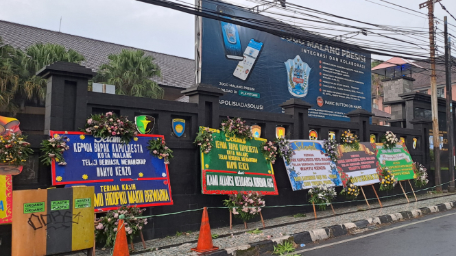 Deretan karangan bunga dari para korban penipuan robot trading berjejer di Markas Polisi Resor Kota (Mapolresta) Malang Kota.