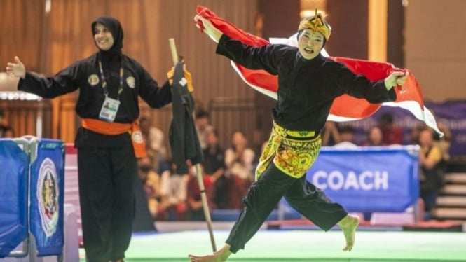 Pesilat putri Indonesia Puspa Arum Sari mengibarkan bendera Merah Putih