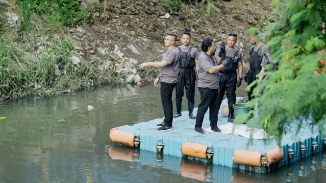 Manajemen dan karyawan PNM membersihkan kali sebagai bentuk mitigasi banjir