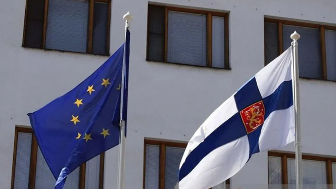 Bendera Uni Eropa dan Finlandia berkibar di luar Kedutaan Besar Finlandia di Moskow, Rusia.