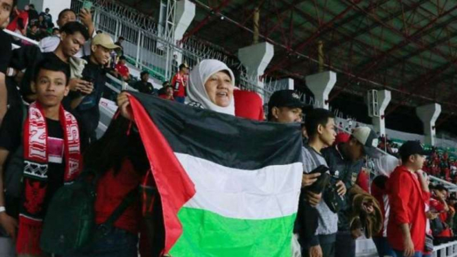 Wakil Ketua DPRD Surabaya Reni Astuti membentangkan bendera Palestina