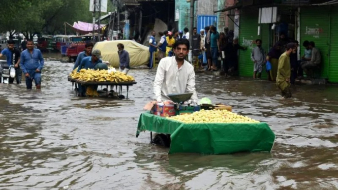 Sejumlah pedagang tetap menjajakan dagangan mereka meski terjadi banjir akibat hujan lebat melanda sejumlah daerah di Pakistan. 